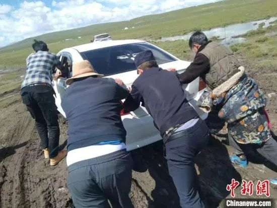 资料图为“移动警务室”的民辅警帮助牧民将深陷泥潭的车推至安全地带。海北州公安局供图 图片